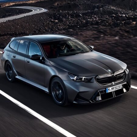 Front-side view of BMW M5 Touring Plug-in Hybrid in motion on a curved mountain road